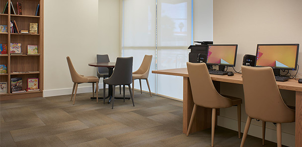 Common space with compute stations, seating area, and bookshelf.